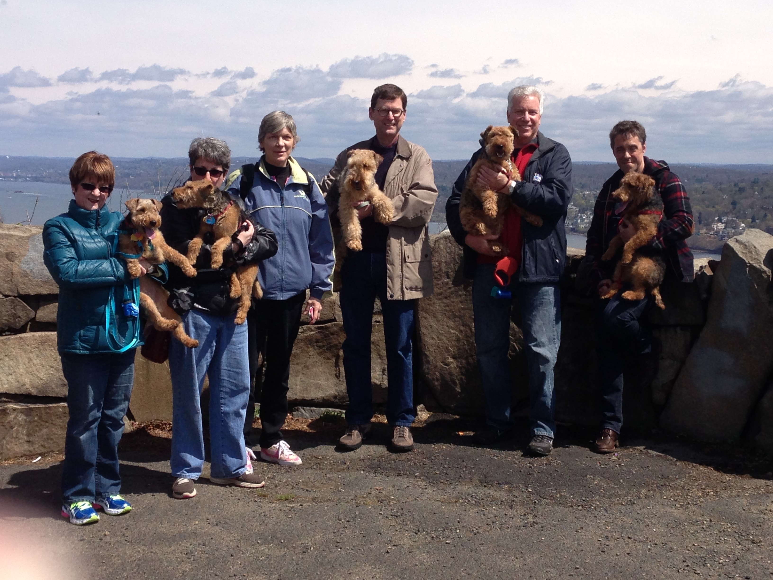 Club members holding Welsh Terriers at a scenic overlook